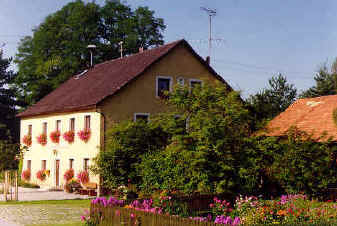 Haus mit blühenden Fensterläden und prächtigem Garten
