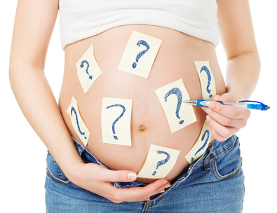 *Bauch einer schwangeren Frau - beklebt mit vielen Fragezeichen (Adobe Stock 102770035)