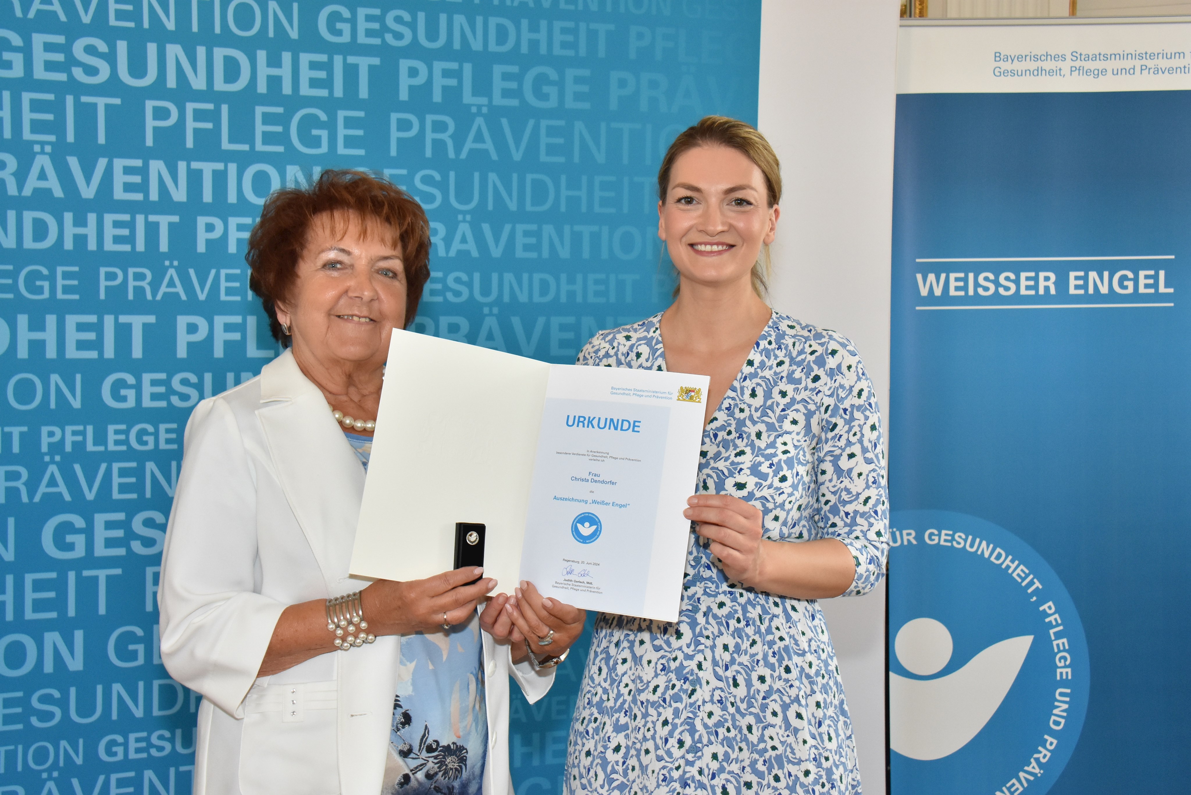 Gesundheitsministerin Judith Gerlach zeichnet Christa Dendorfer (links) mit dem „Weißen Engel“ aus.